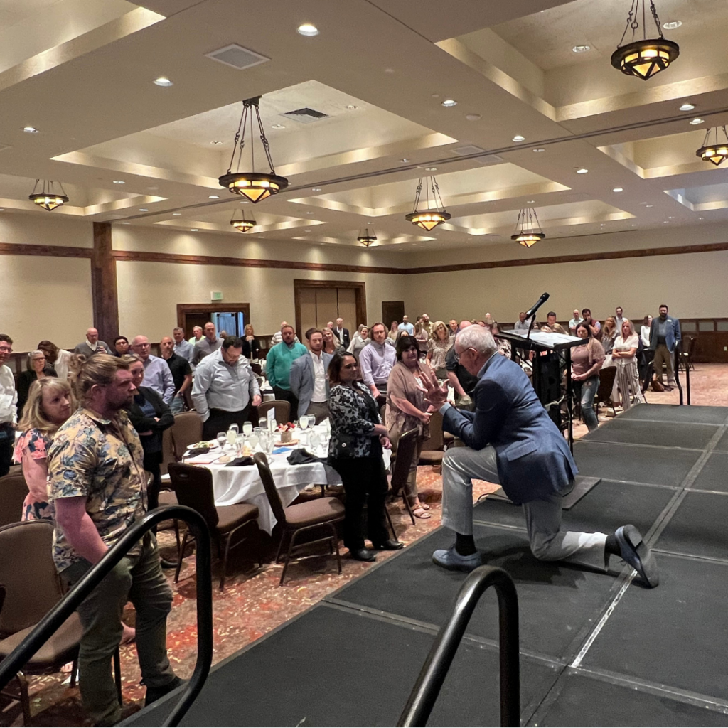 Image of Sam Beard kneeling at a conference