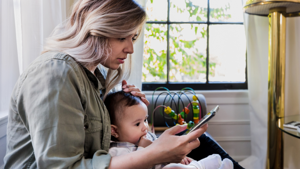 Technology Tips: Image of a mother with young child looking at her phone for parental tips