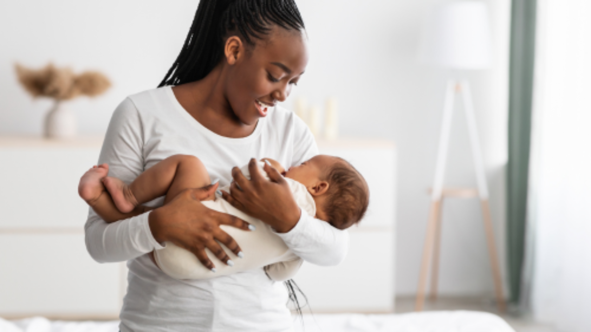 Proof: Image of a Young black mother holding her young sleeping baby.